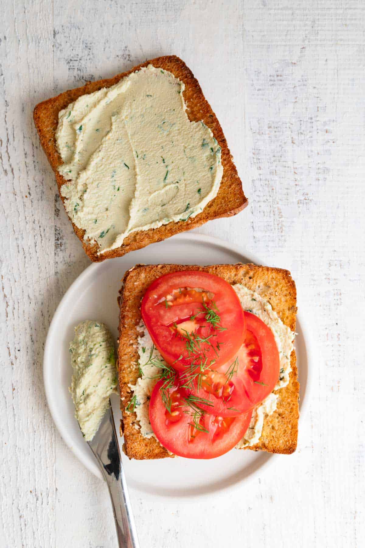 Dairy-free cream cheese on toast with tomatoes and fresh dill.