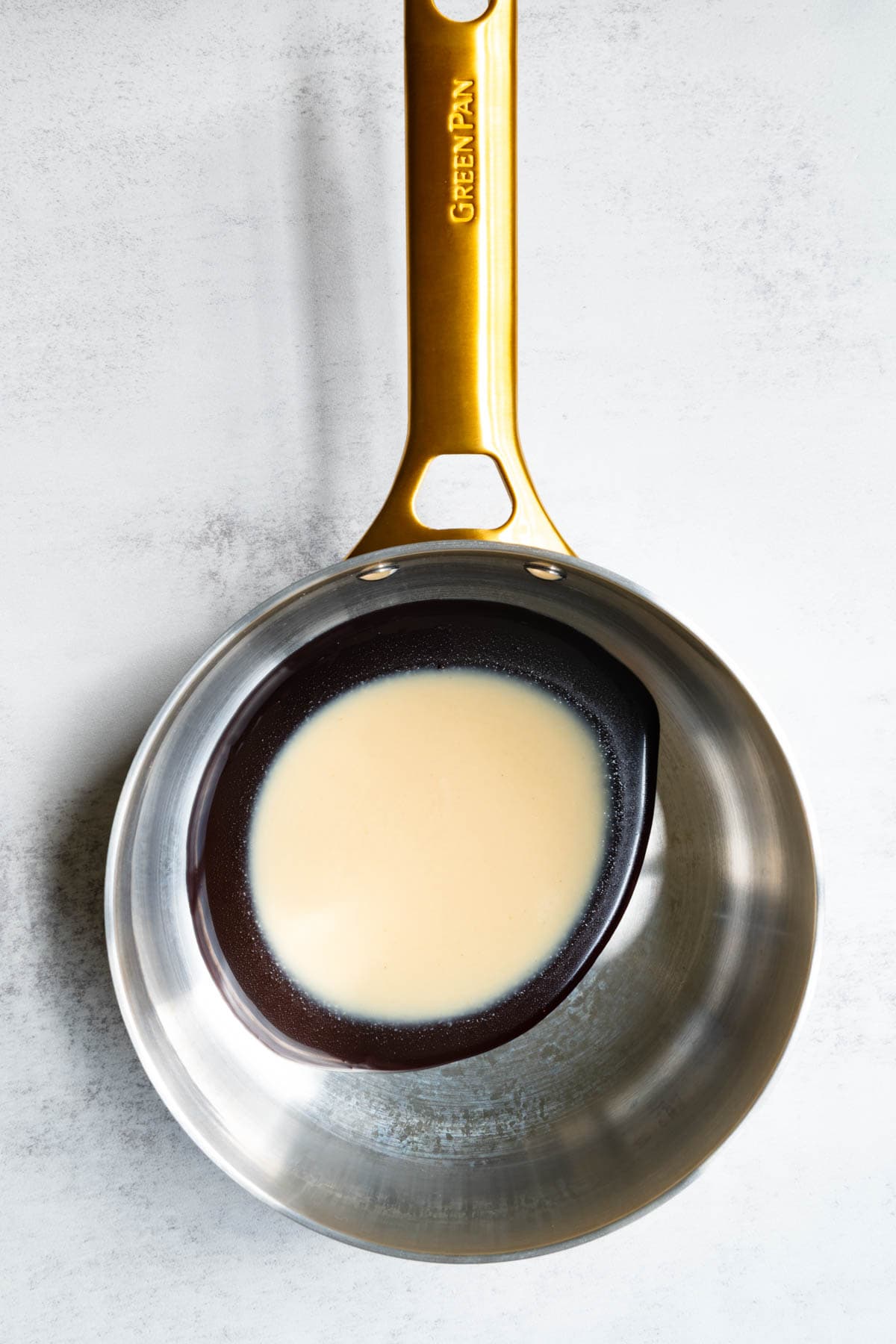 Date syrup and tahini in a stainless steel saucepan.