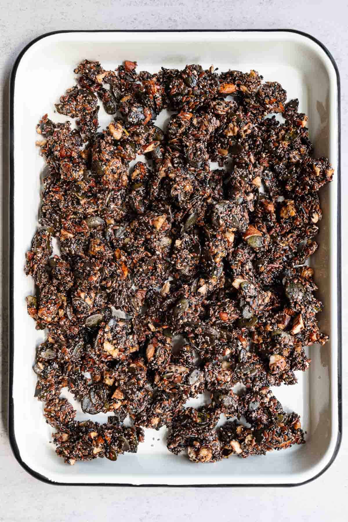 Crunchy and healthy grain-free granola on a white baking sheet.