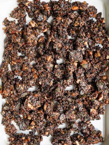 Crunchy and healthy grain-free granola on a white baking sheet.