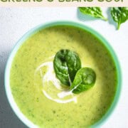 High-protein creamy greens and beans soup in a bowl topped with greens.