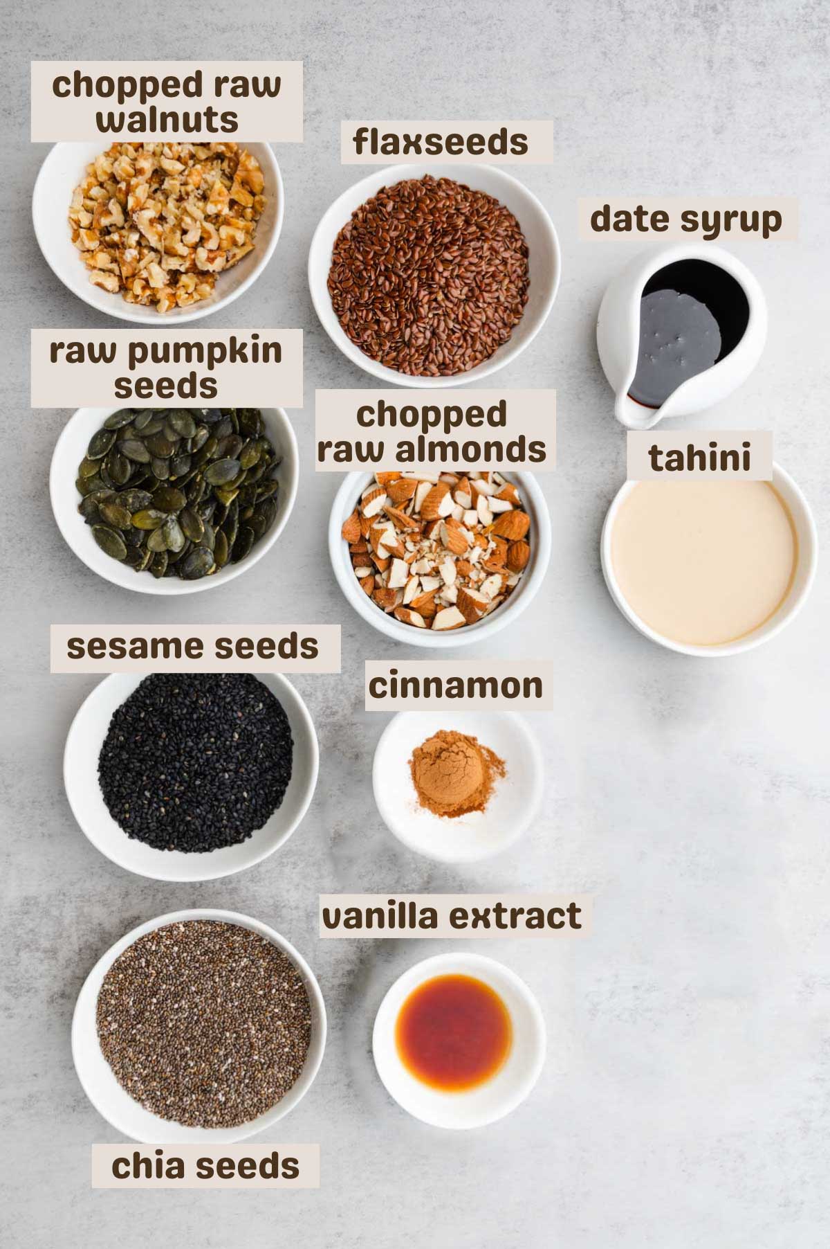 Chopped walnuts and almonds, pumpkin seeds, flaxseeds, chia seeds, date syrup, tahini, sesame seeds, cinnamon, and vanilla extract.