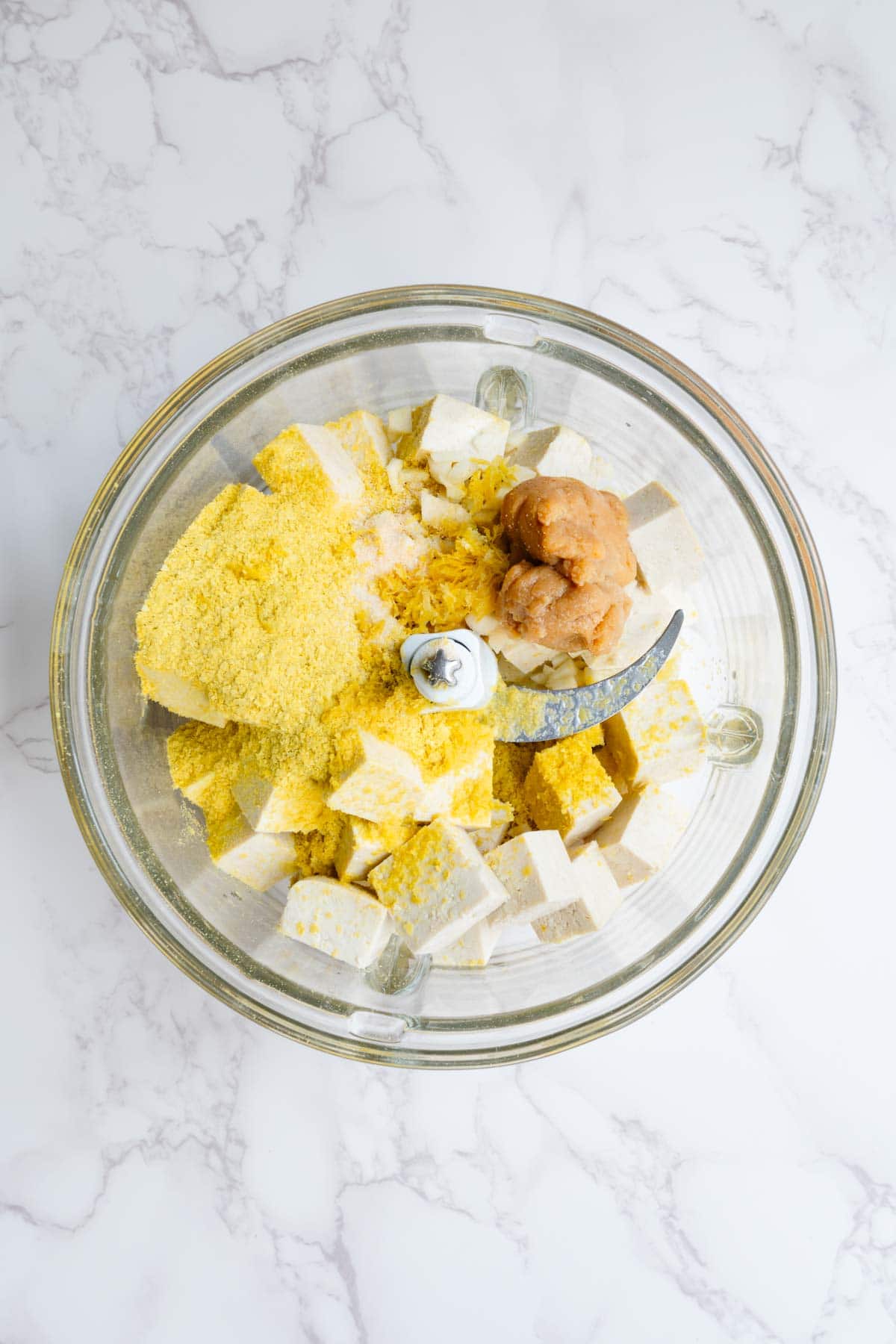 Tofu, cream cheese, miso, nutritional yeast, herbs, lemon, onion powder, and garlic.