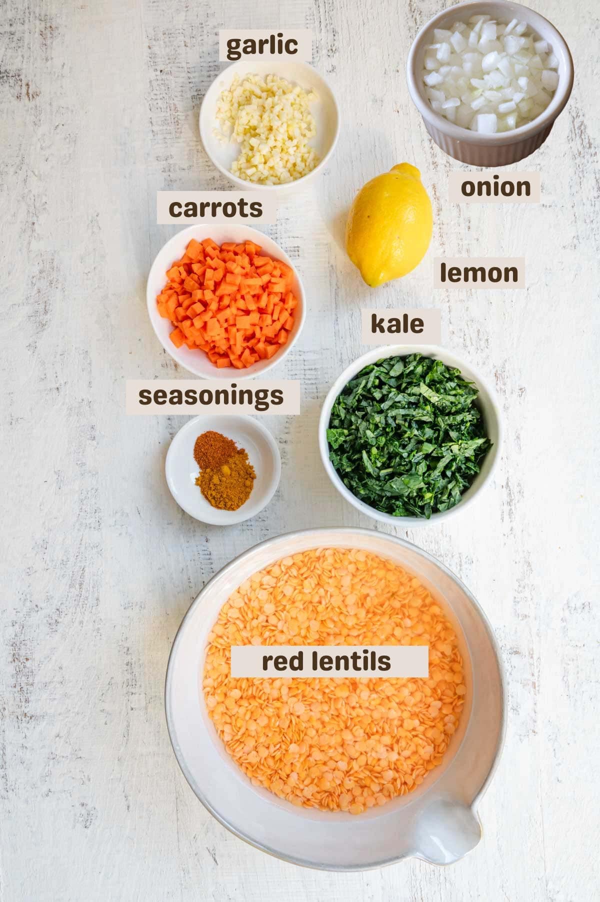 Minced garlic, soaked red lentils, kale, seasonings, chopped carrot, and lemon.