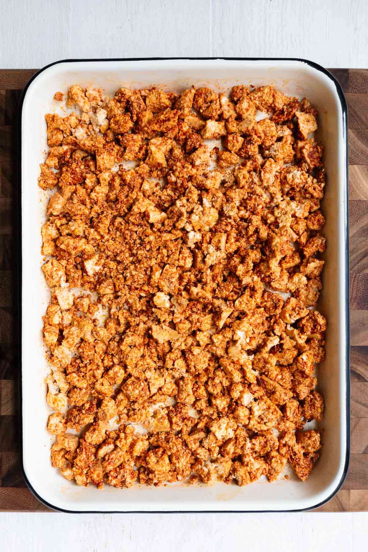 Vegan sausage crumbles made with tofu on a baking sheet.