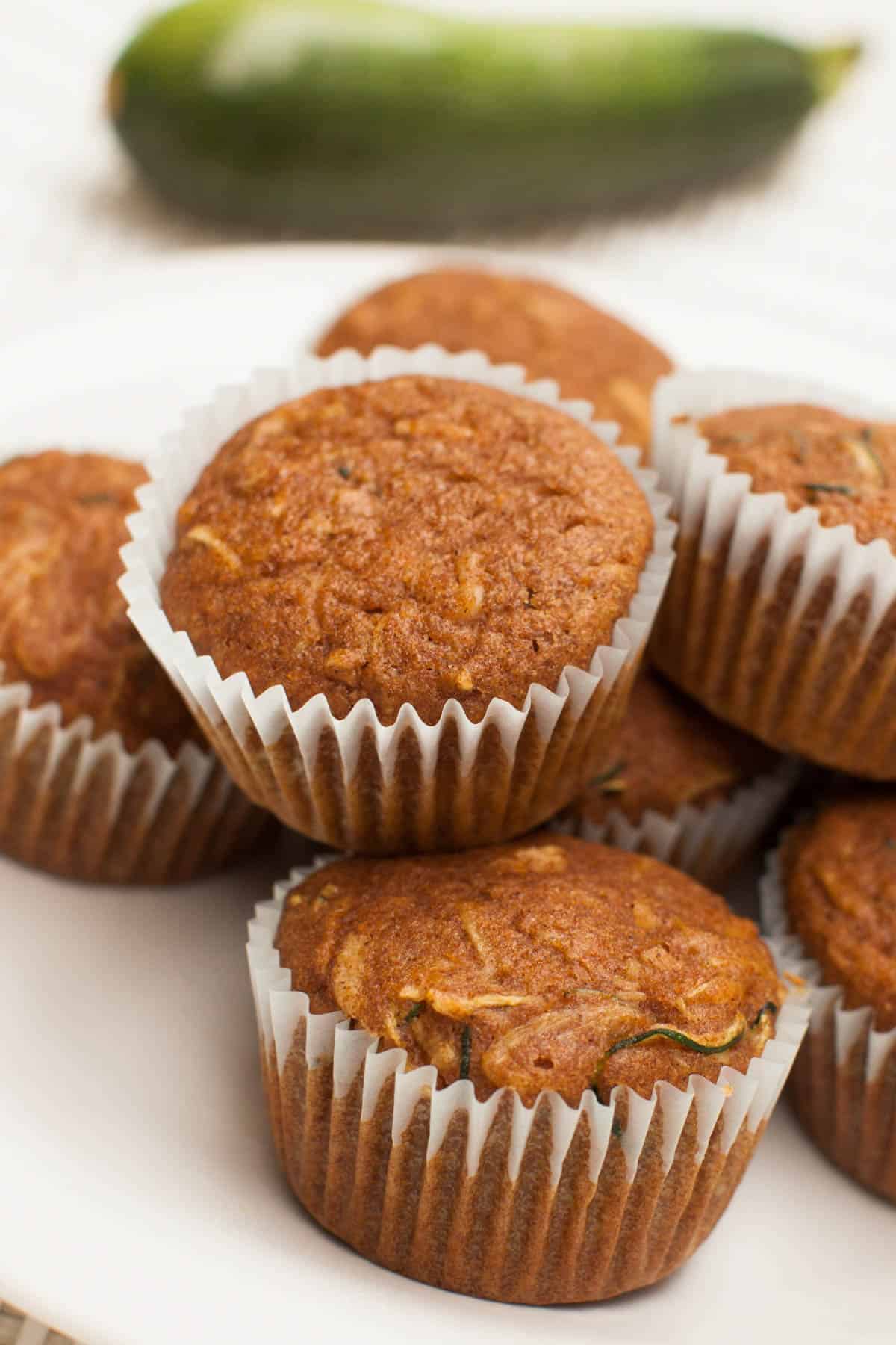 High-protein zucchini muffins beside a whole zucchini.