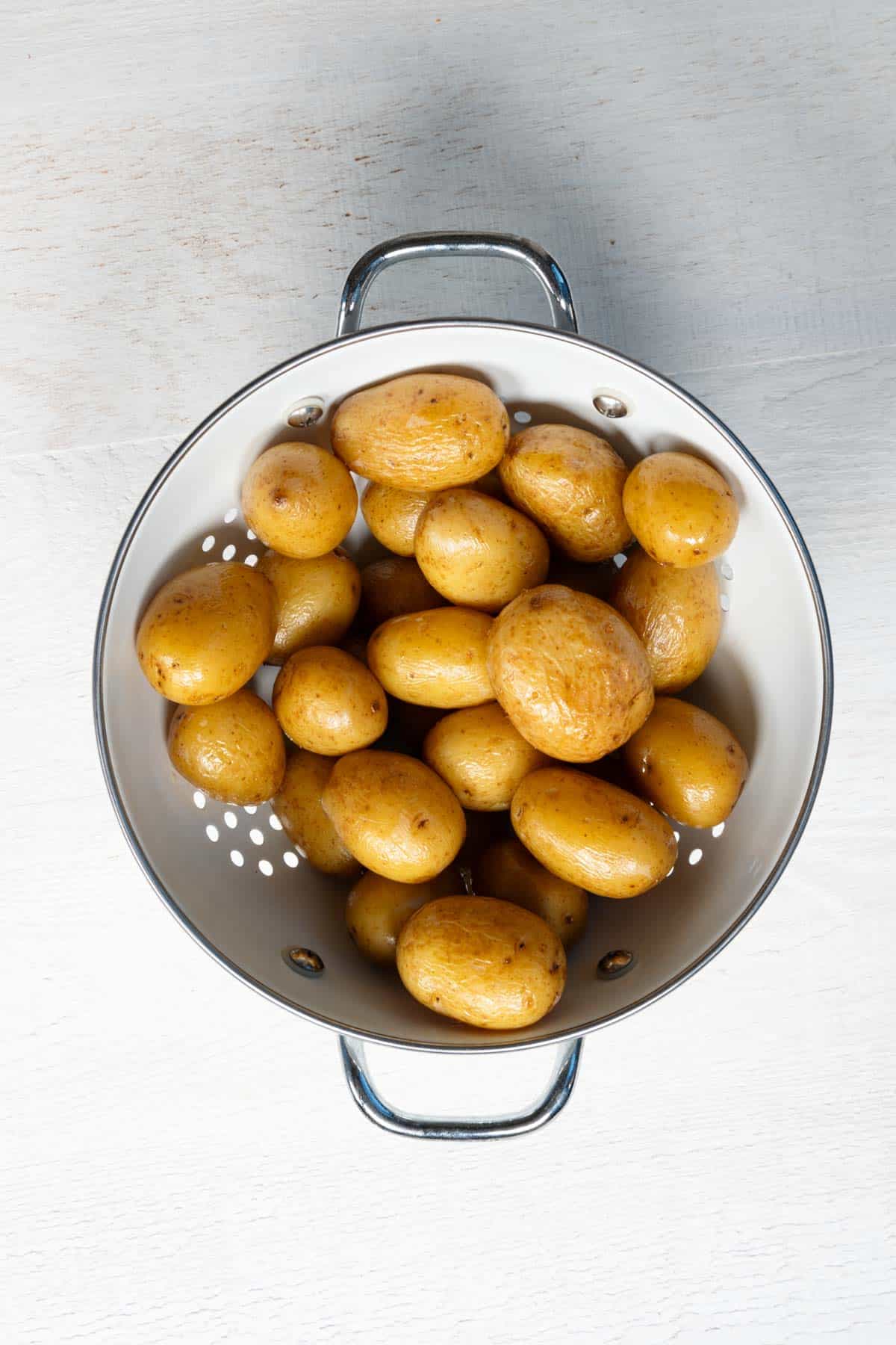 Baby potatoes in a white colander.