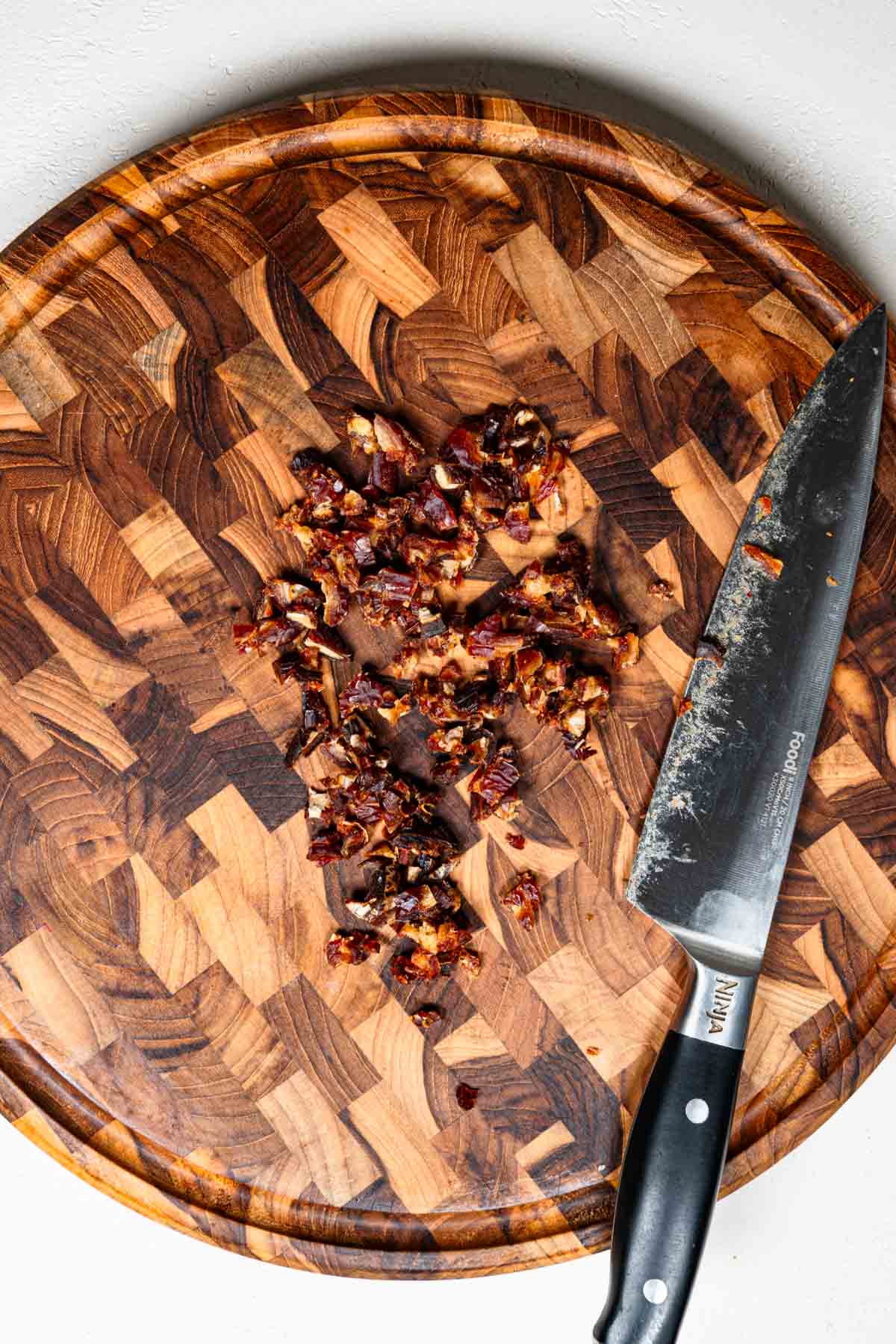 Chopped dates on a wooden cutting board.