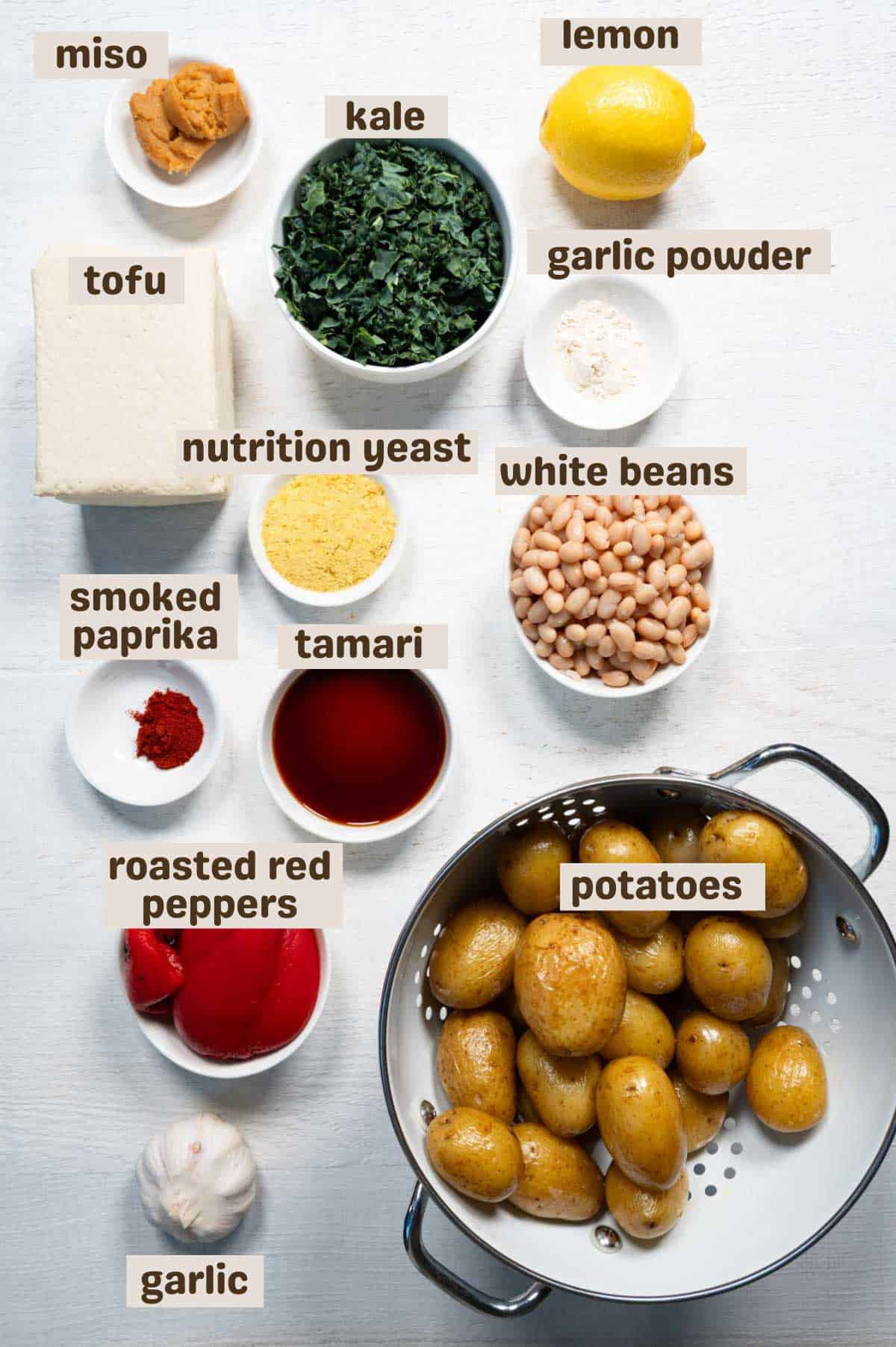 Baby potatoes, chopped kale, tofu, miso, roasted red peppers, lemon, garlic powder, garlic, smoked paprika, tamari, nutritional yeast, and white beans.