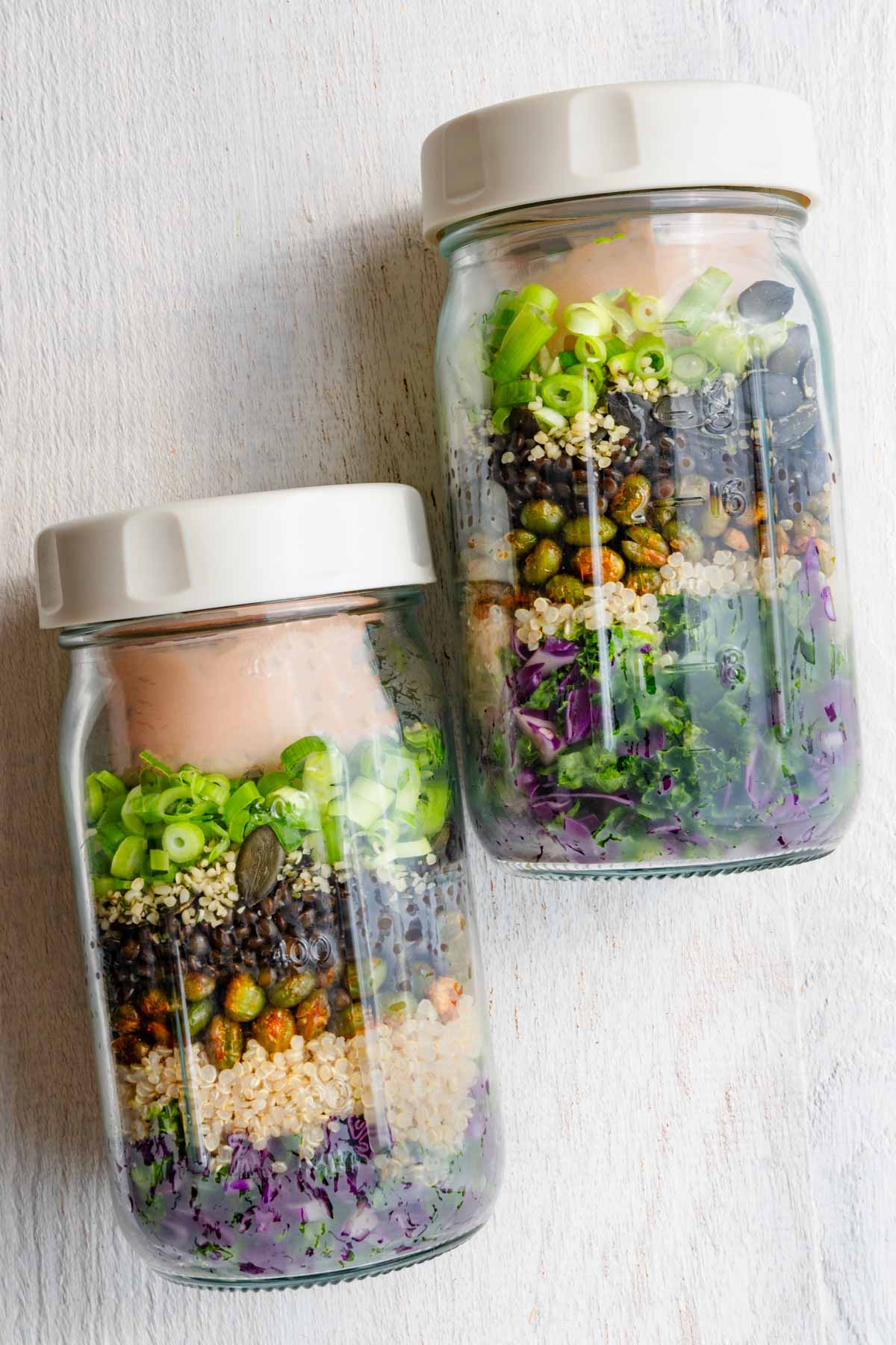 Protein lentil quinoa salad in two glass jars for grab-and-go lunches.