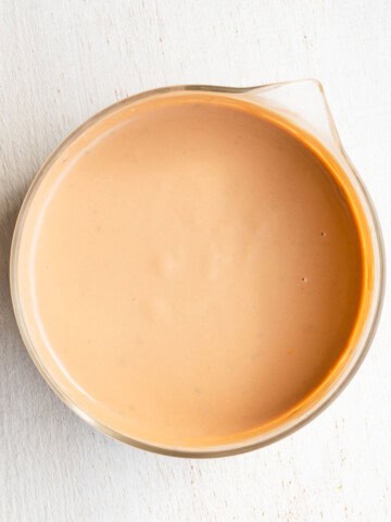 Light tahini dressing in a glass bowl.