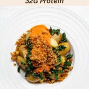 Loaded potato bowl with sliced baby potatoes, tofu crumbles, chopped kale, and red sauce in white bowls.