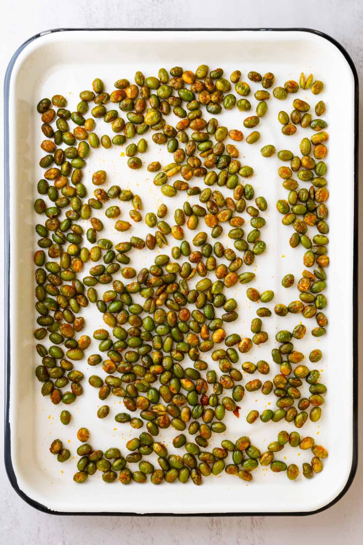 Roasted edamame on a baking tray.