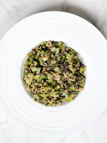 Shaved Brussels Sprouts & Celery Anti-Cancer Salad in a white bowl.