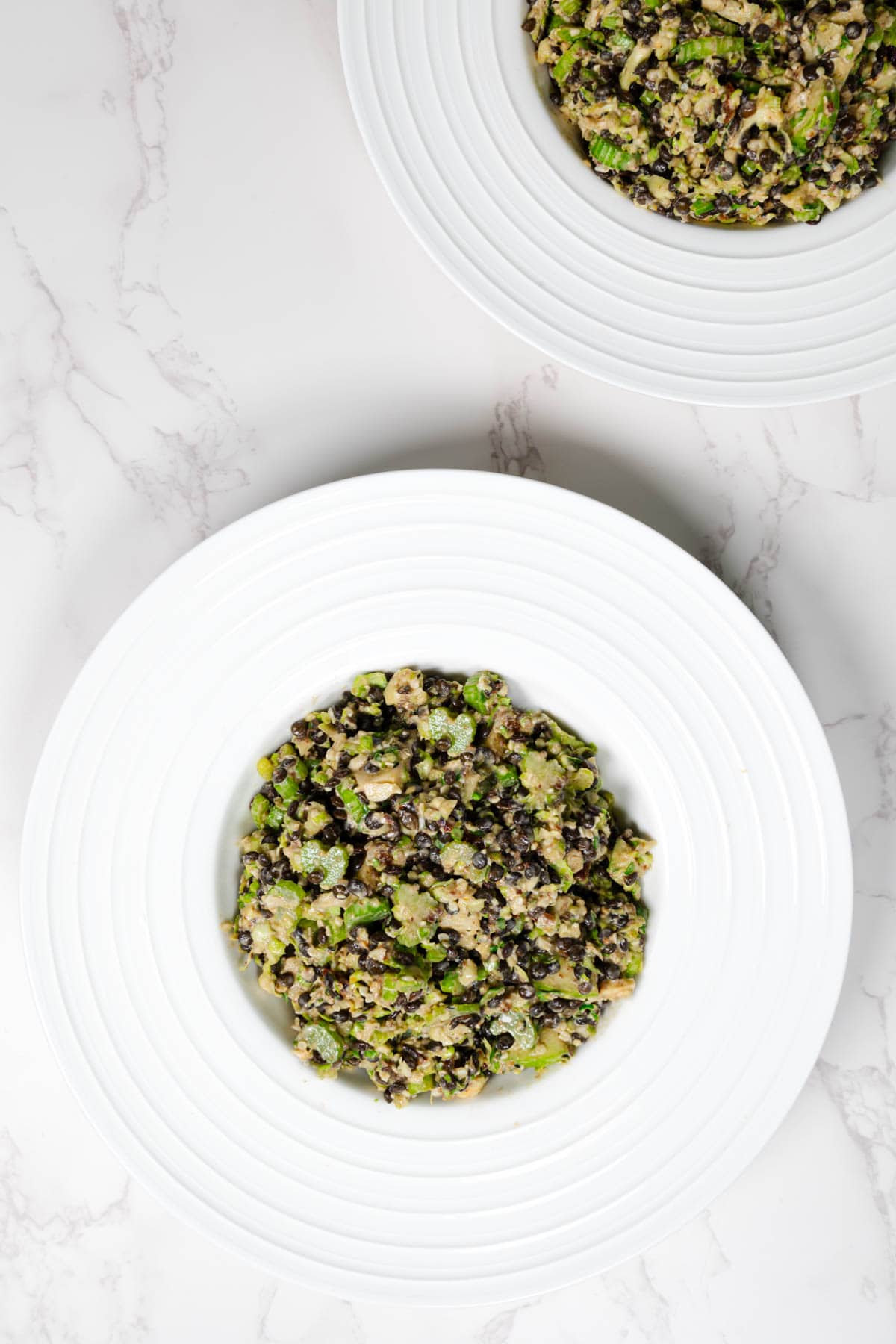 Shaved Brussels and Celery Anti-Cancer Salad in a white bowl.