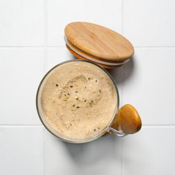 Blended protein oats in a glass serving jar with wooden spoon and lid.