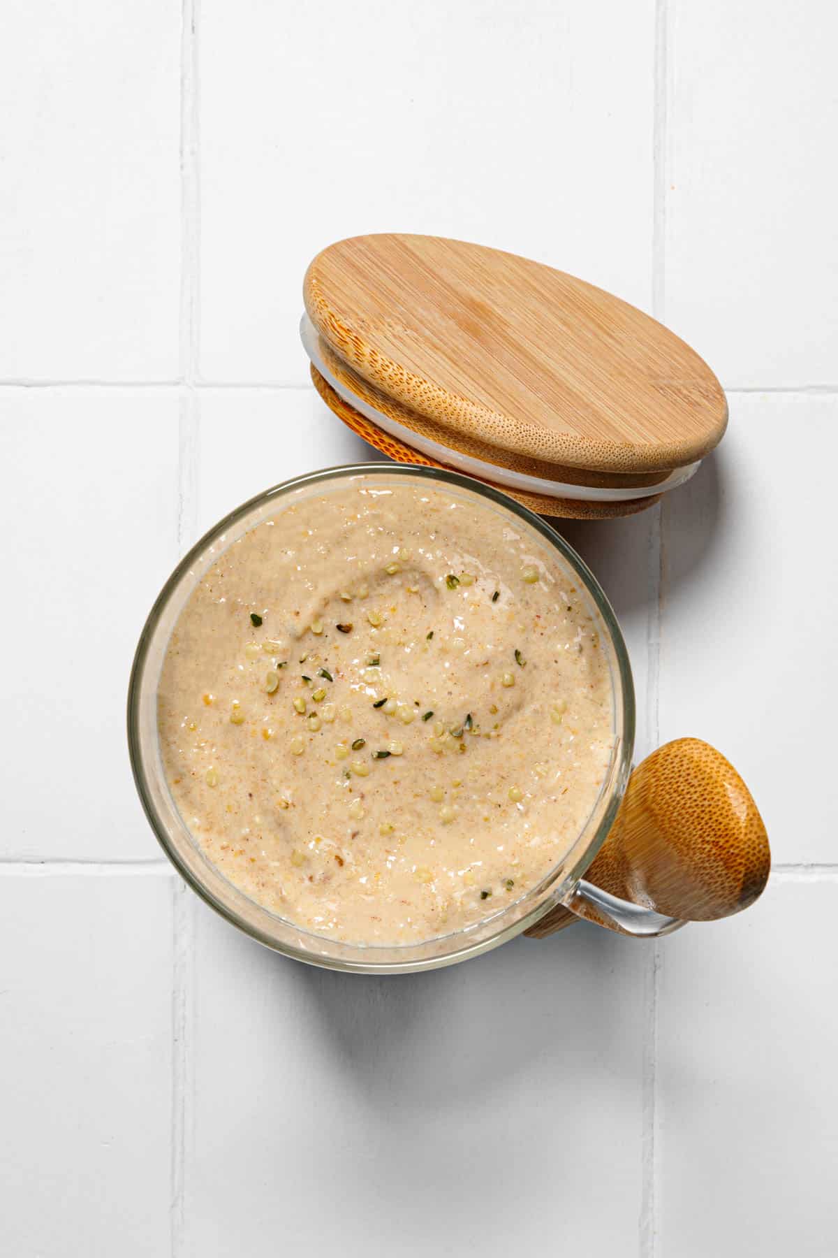 Blended protein oats in a glass serving jar with wooden spoon and lid.