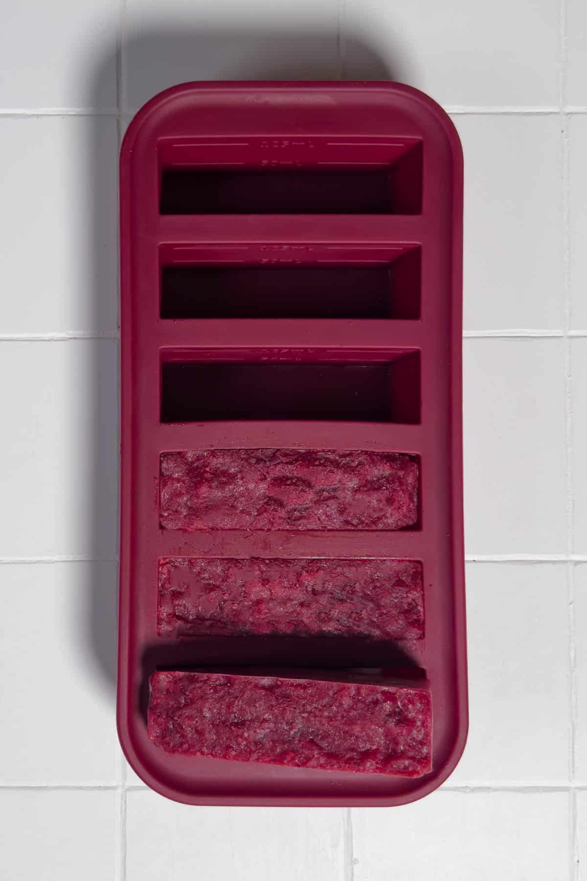 Frozen cranberry sauce in soupercube storage tray.