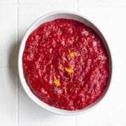 Cranberry sauce in a bowl with a sprinkle of lemon zest.
