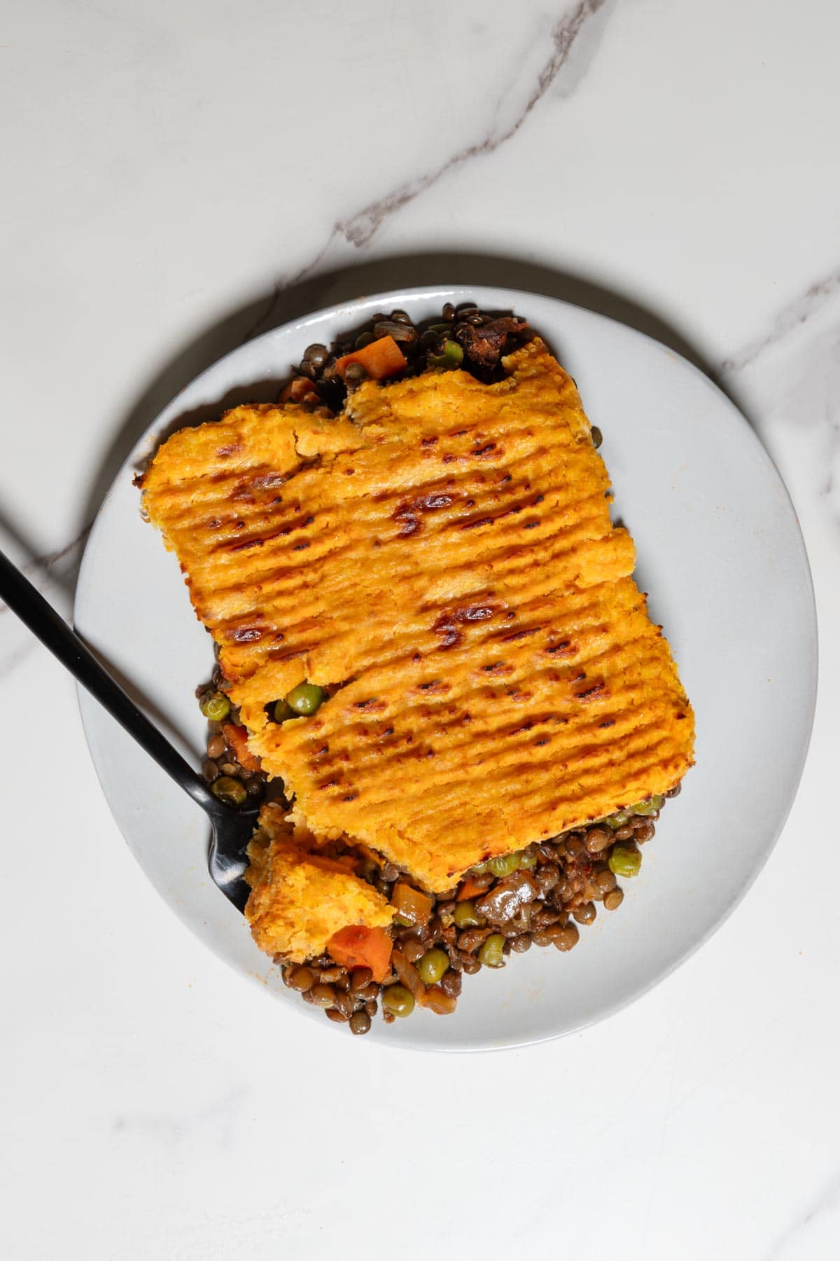 Vegetarian Lentil Shepherd's Pie ion a plate with a fork.