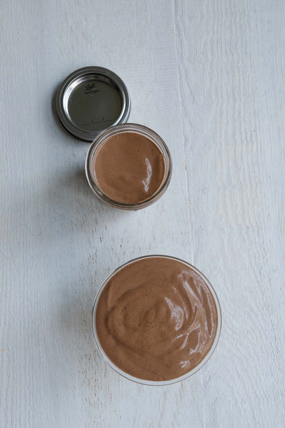Blended brown creamy liquid in two containers for meal prep.