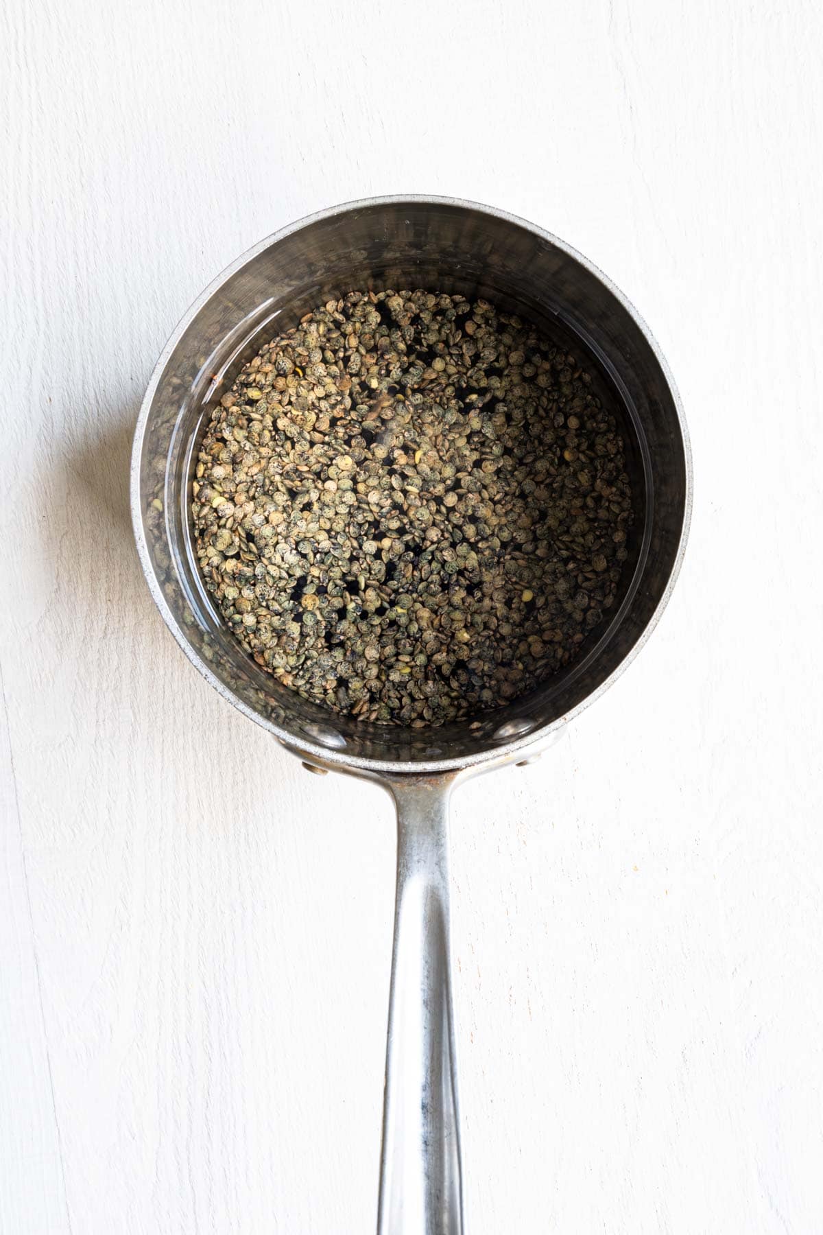 Simmered green lentils in a saucepan.