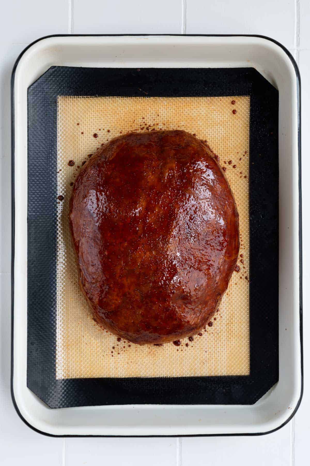 Thanksgiving Vegan Turkey baked on a silicone mat on a white baking tray.