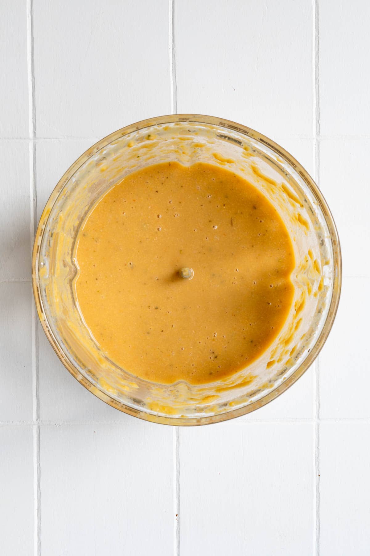 Blended chickpeas, vegetable broth, and seasoning in a food processor.