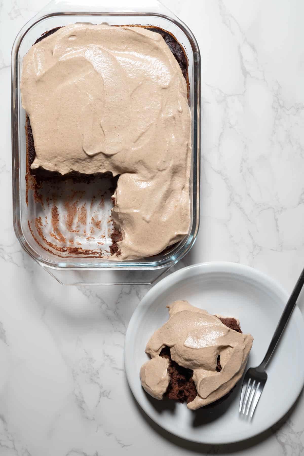 Black bean brownies with walnut cream frosting served on a white plate.