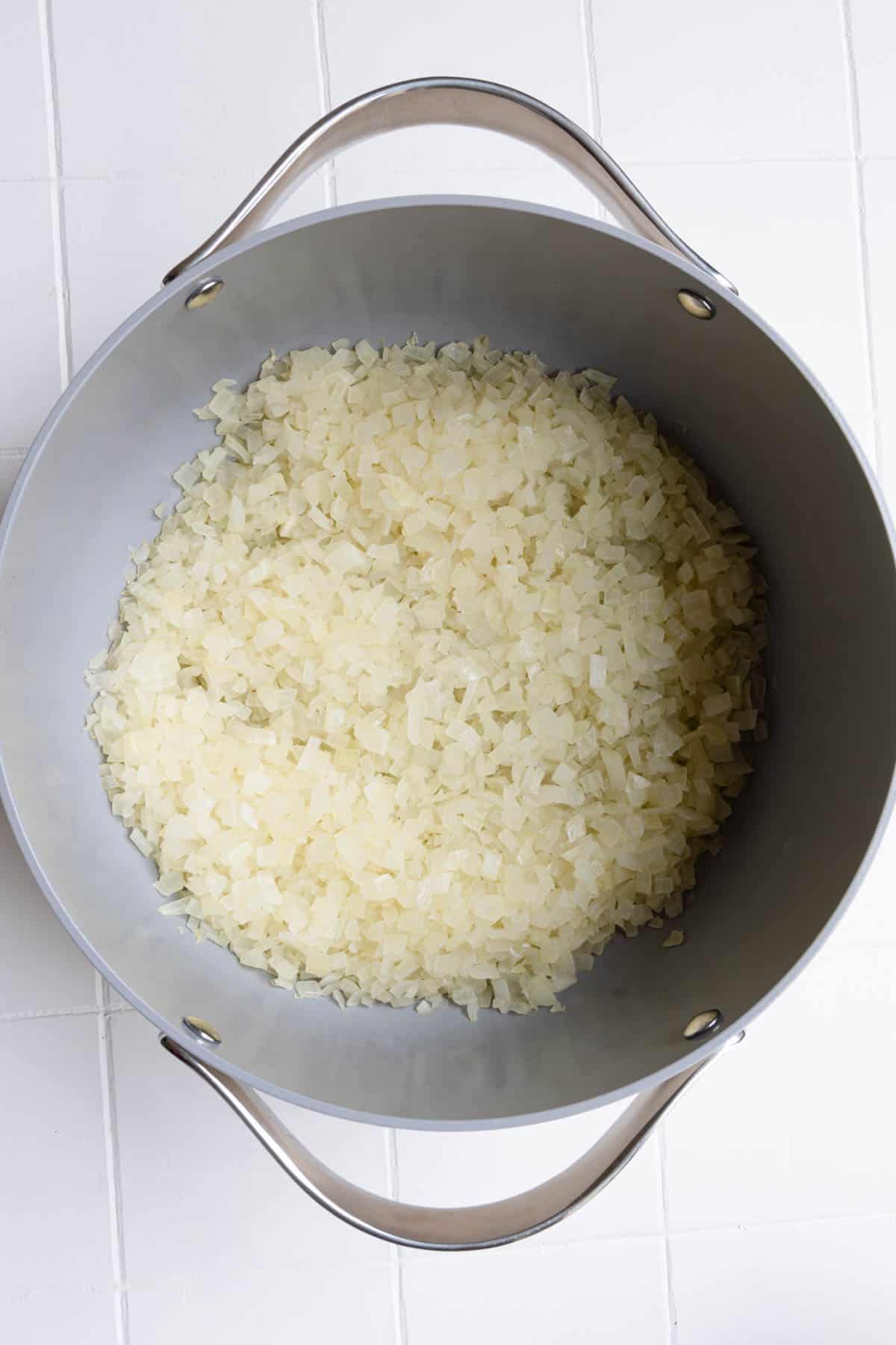 Softened cooked chopped onion in a saucepan.