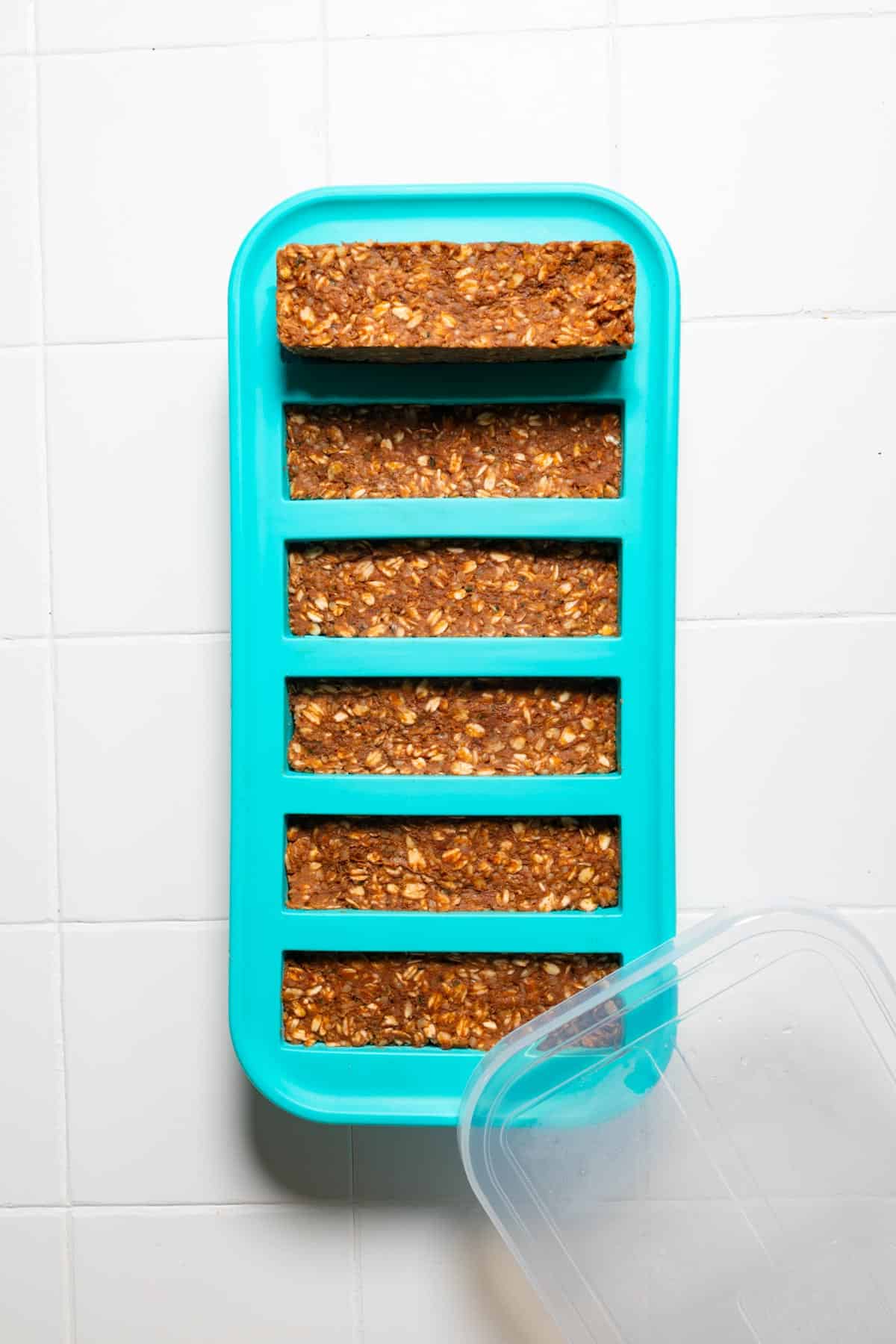 Homemade protein no-bake granola bars in a blue Souper Cube six-slot long rectangular silicone freezer tray.