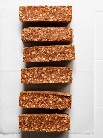 Six homemade high-protein granola bars(no bake) on white parchment paper.