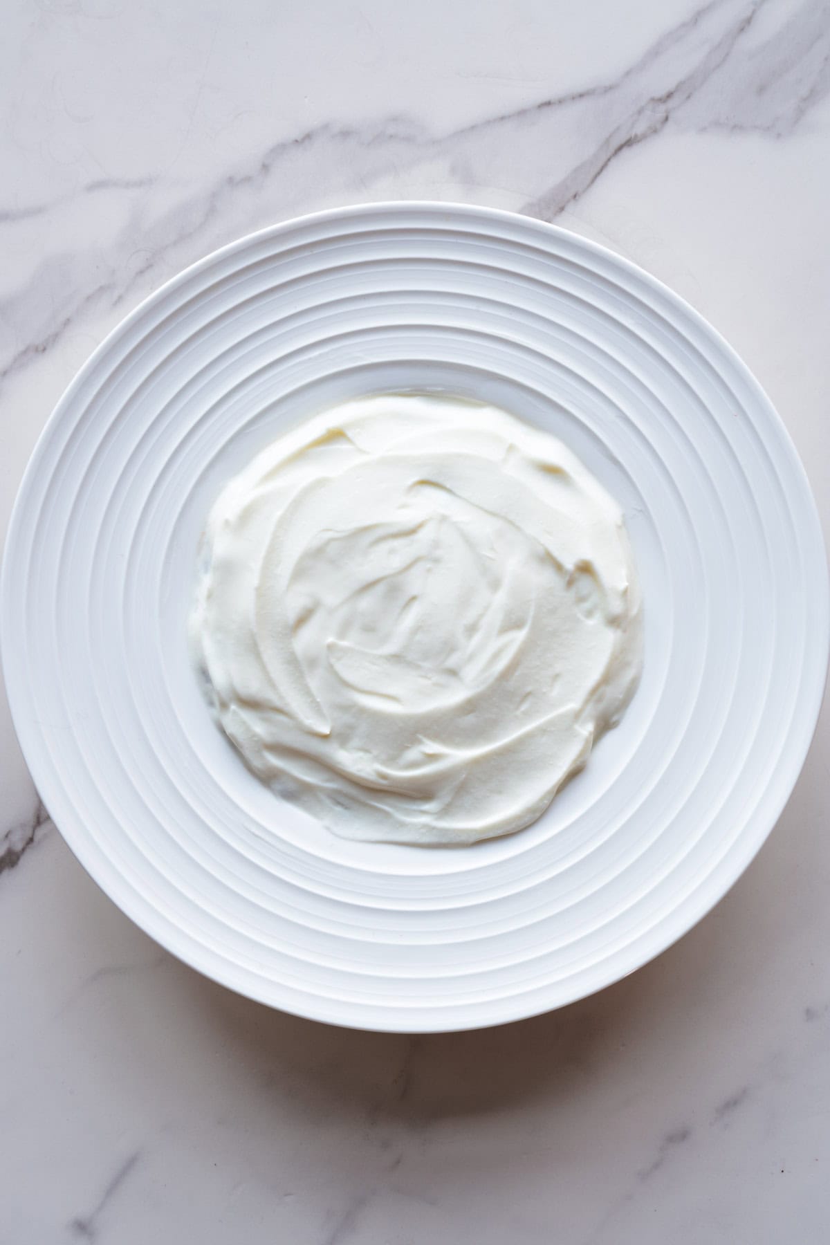 Greek style yogurt in a white bowl.