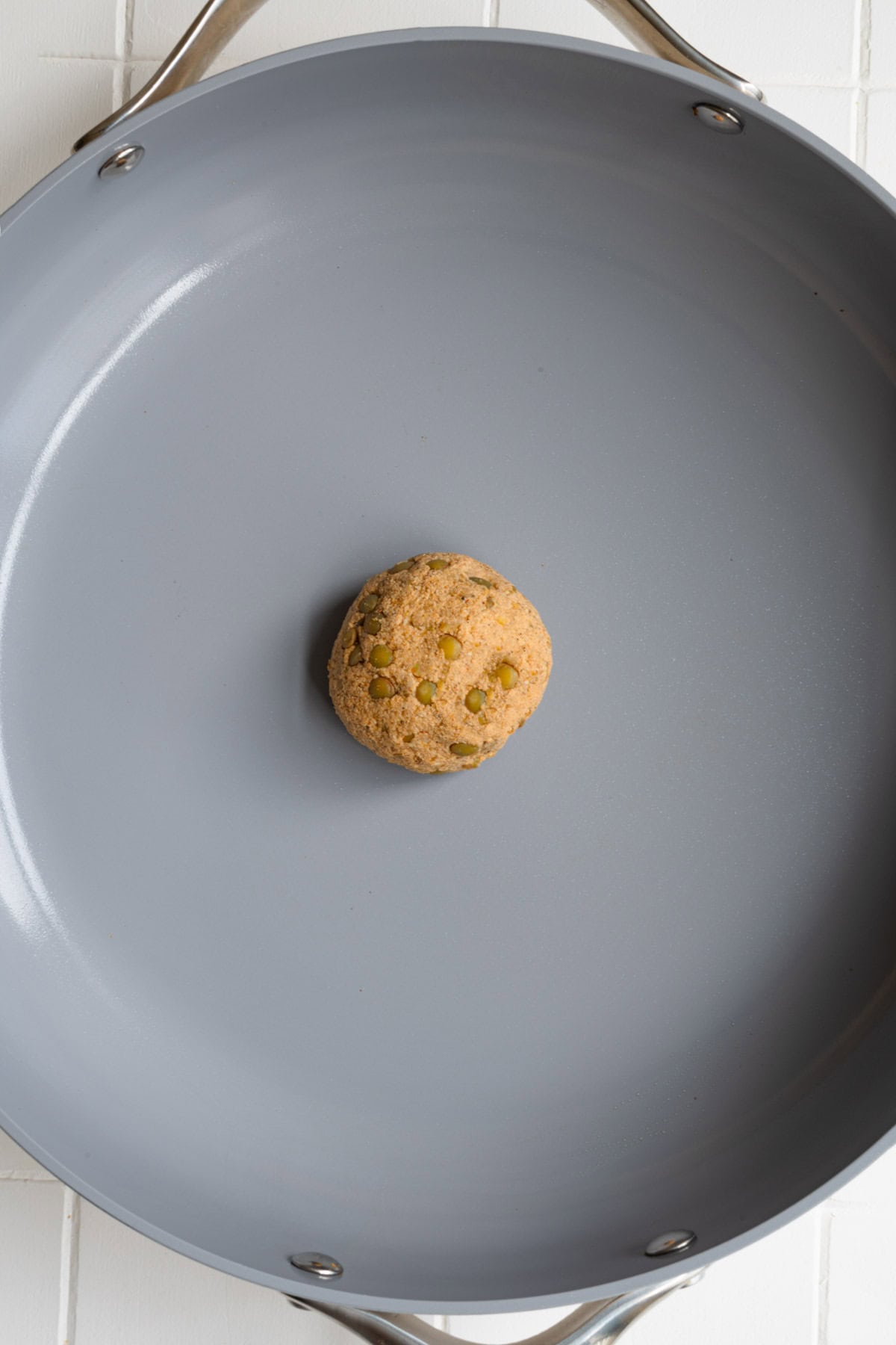 Rolled vegan patty in a nonstick skillet.