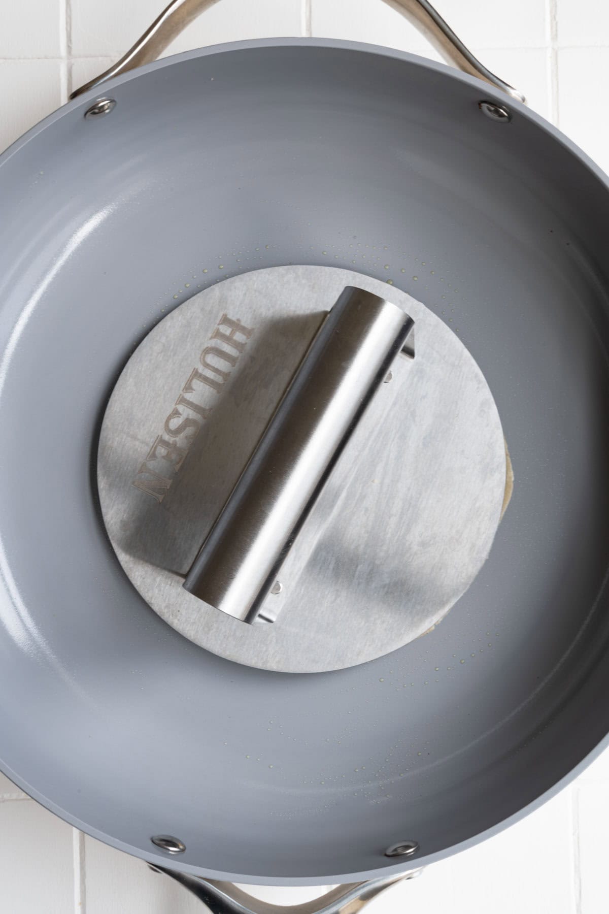 Burger smasher in a nonstick skillet.