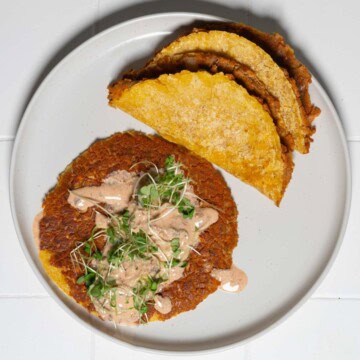 Vegan smash burger tacos with burger sauce on a white plate.