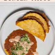 Vegan smash burger tacos with burger sauce on a white plate.