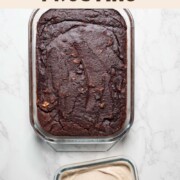 Black bean brownies in a glass baking dish next to a container of walnut cream frosting.