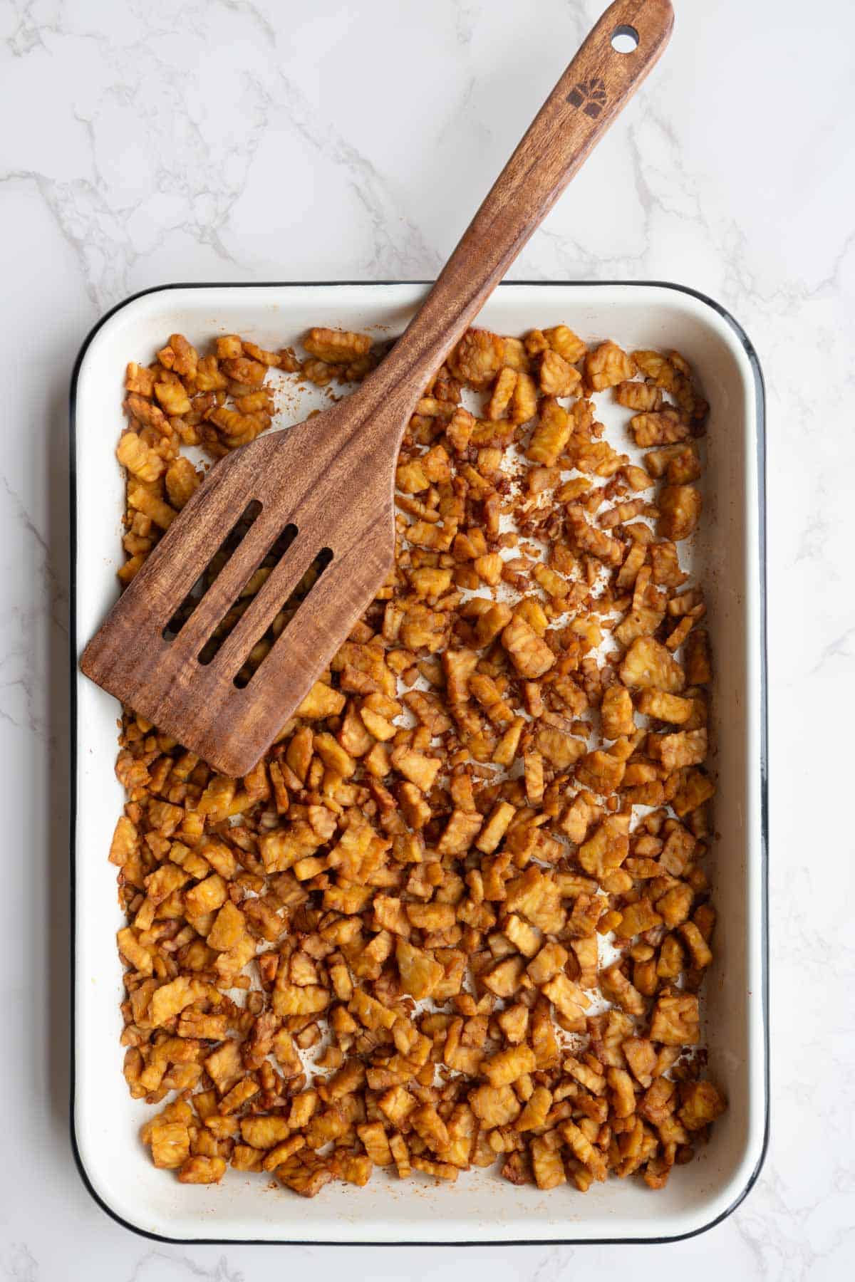Crispy tempeh on a white baking sheet.