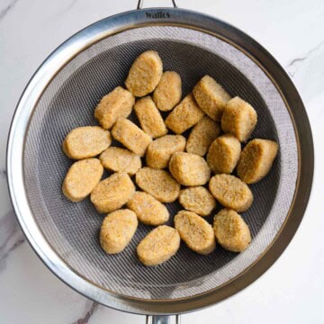 Homemade gnocchi in a fine mesh sieve.