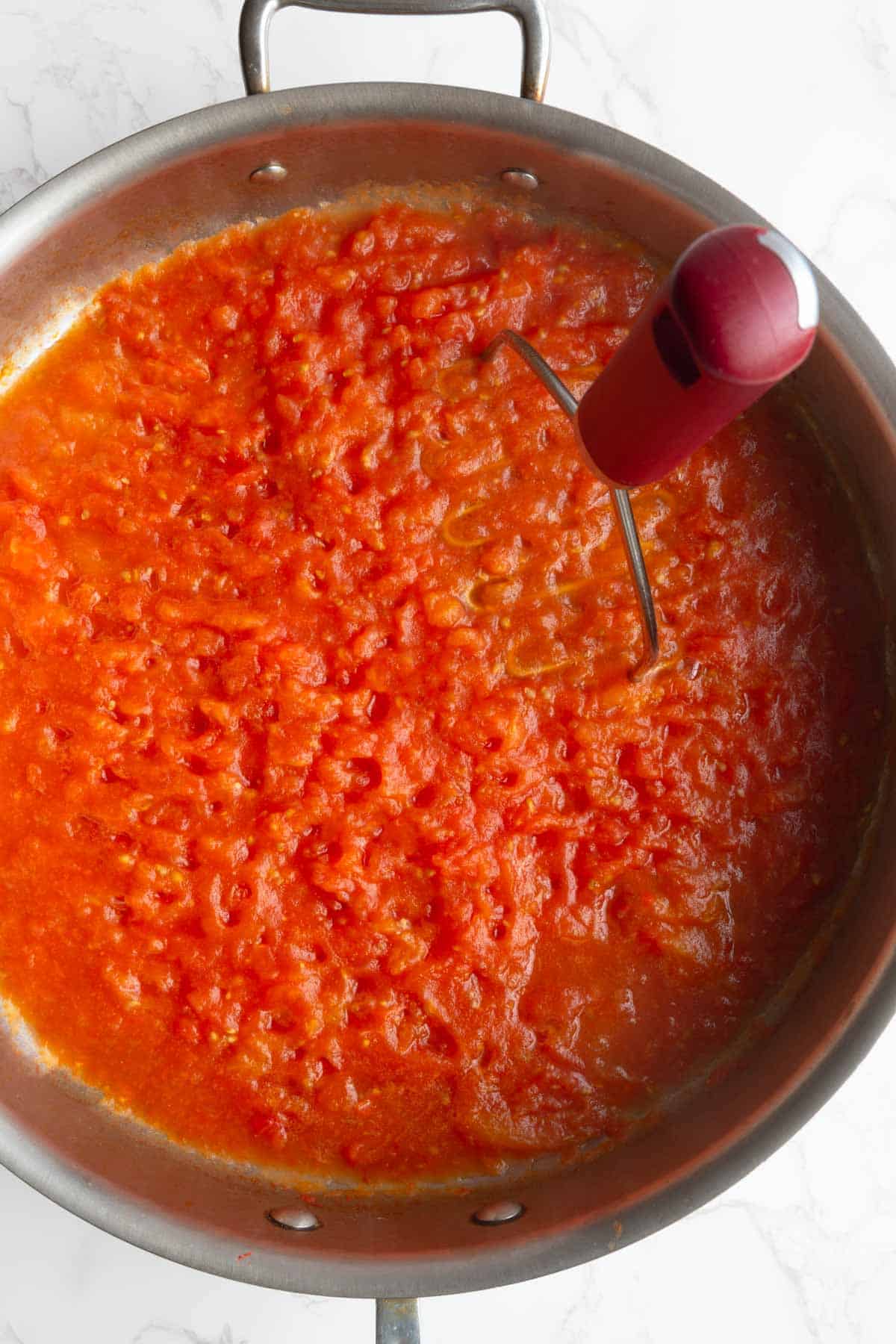 Cooked crushed tomatoes in a large skillet.