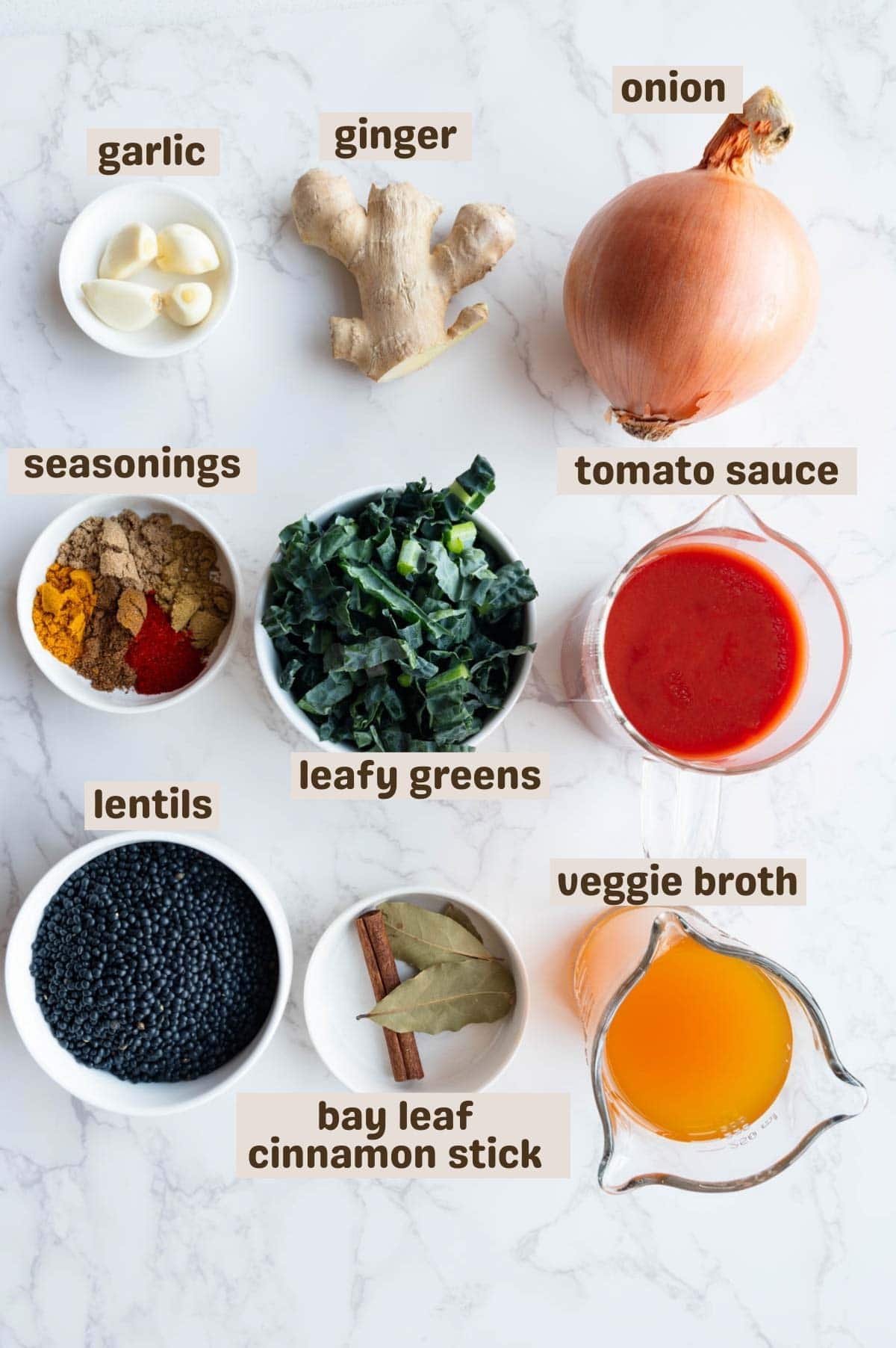 Garlic, ginger, chopped greens, bay leaves, cinnamon stick, lentils, tomato sauce, vegetable broth, seasonings, and onion.