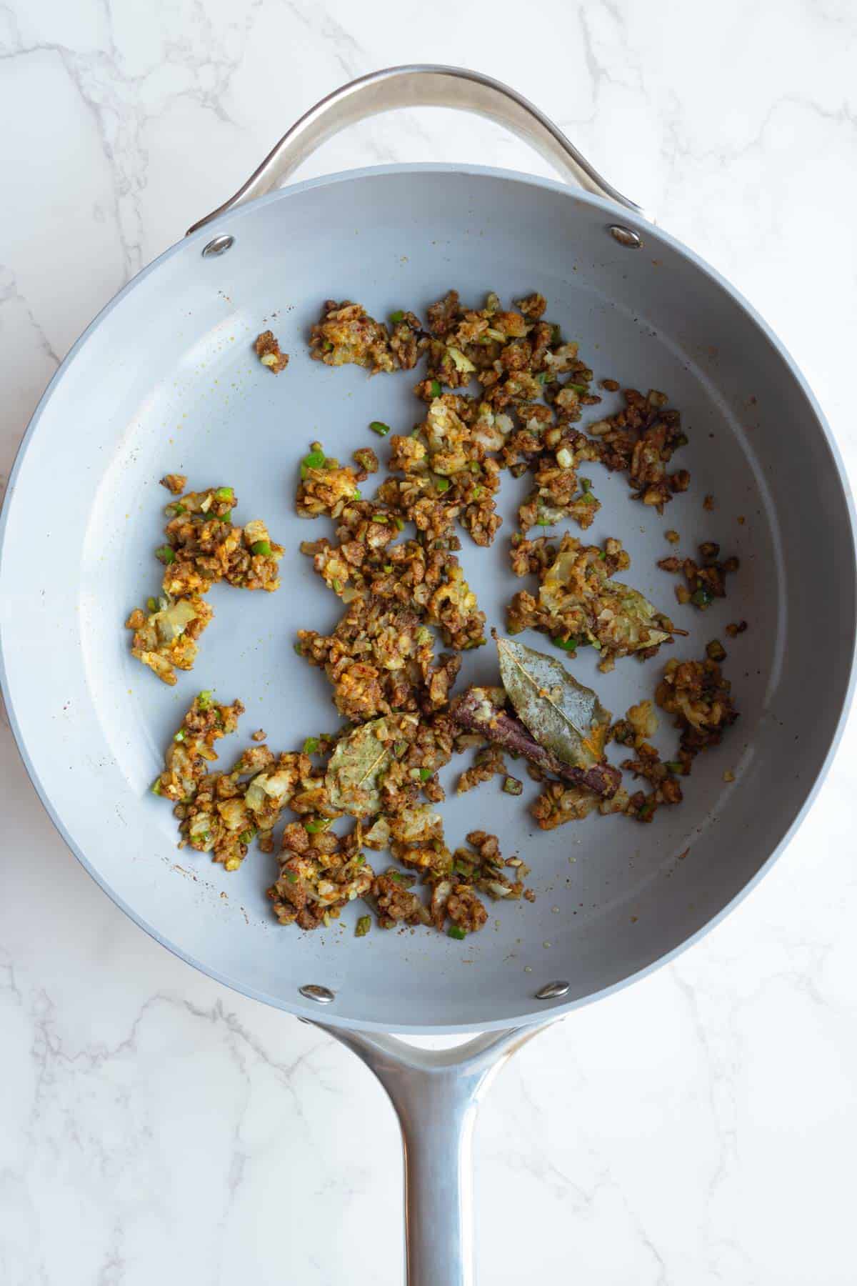 Cooked aromatics and seasoning in a large skillet.
