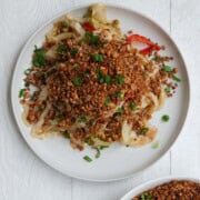 Pan-fried tofu crumbles in a bowl and sprinkled on a cabbage stir fry.