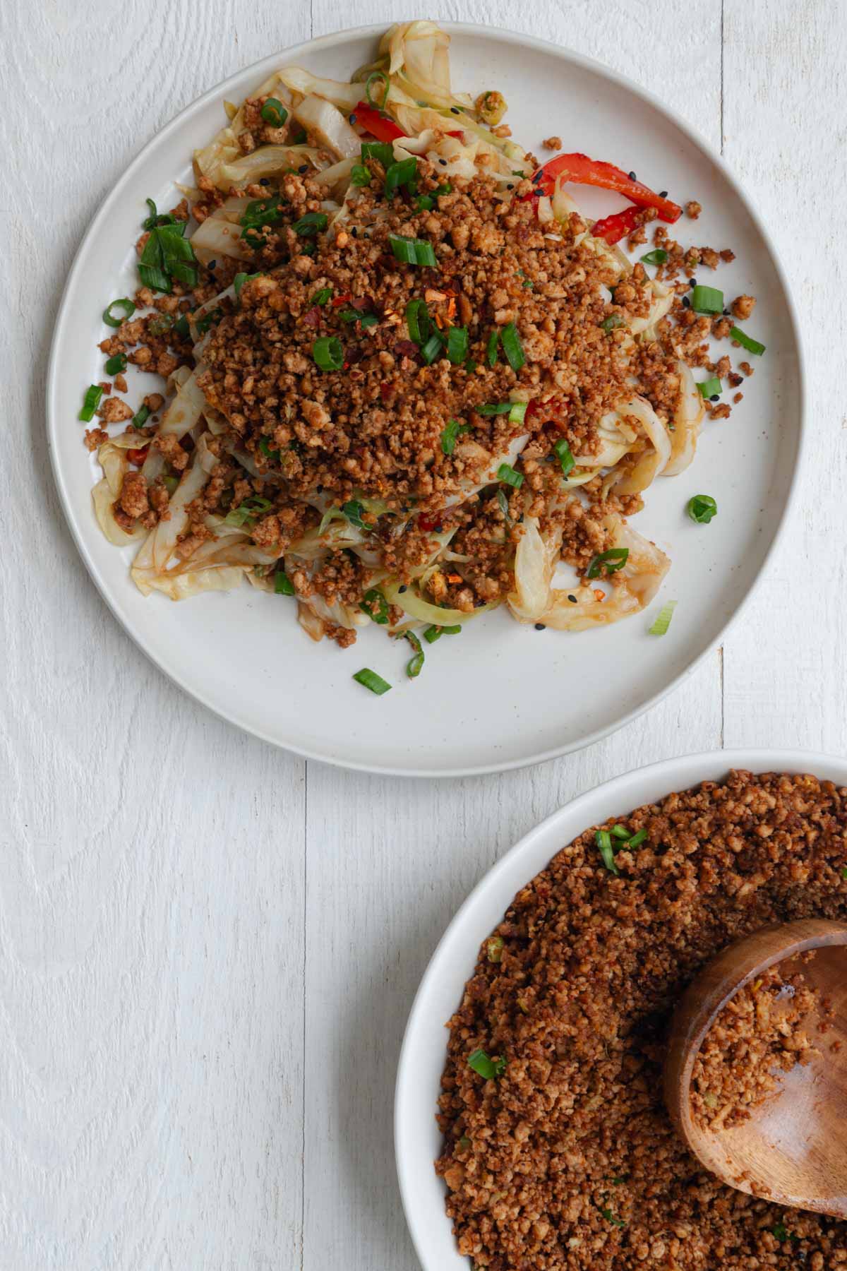 Pan-fried tofu crumbles in a bowl and sprinkled on a cabbage stir fry.