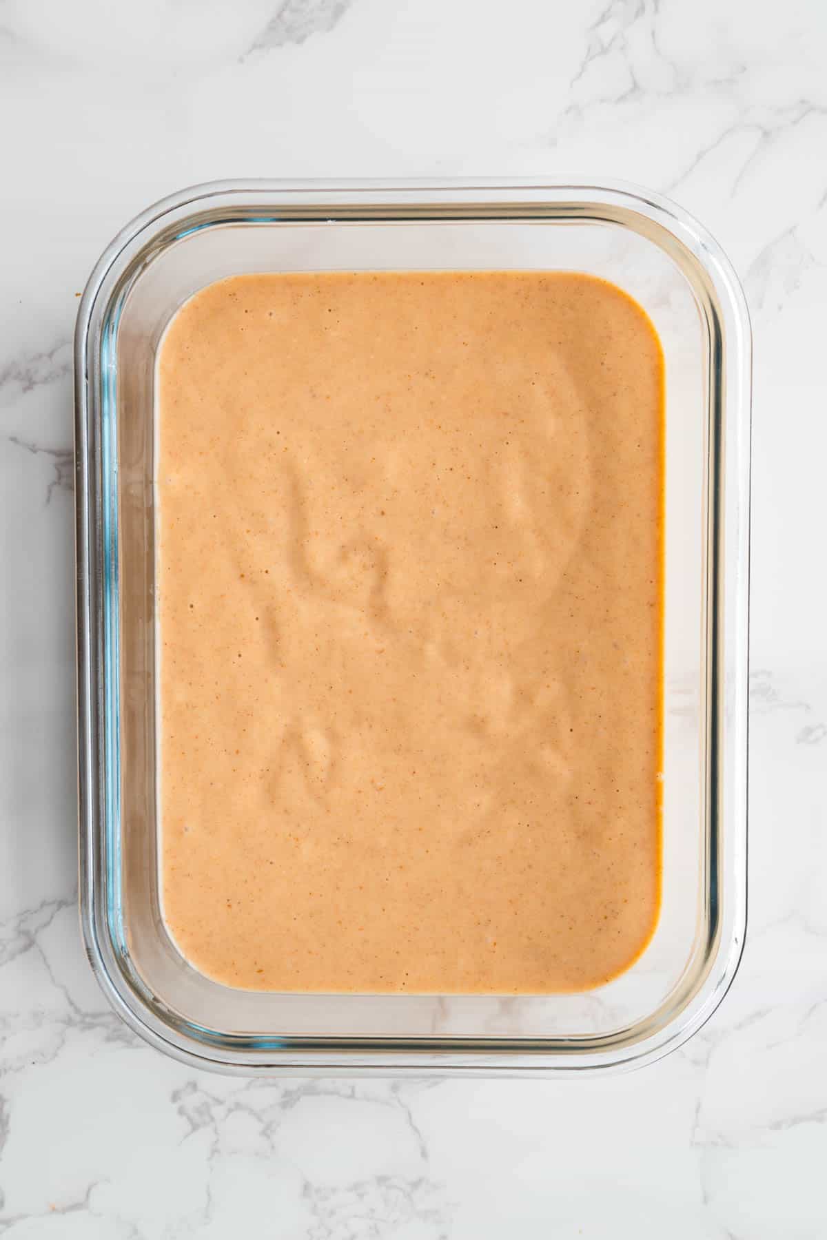 Red lentil pancake batter in a glass dish.