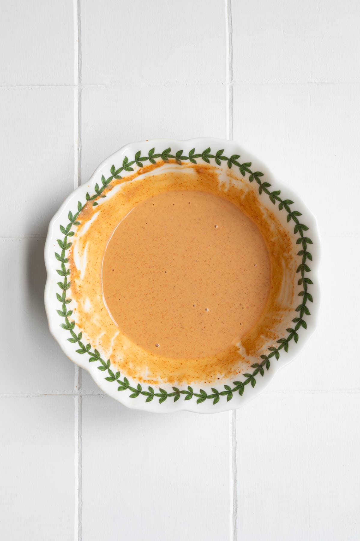 Smoky lemon herb tahini dressing in a white bowl.