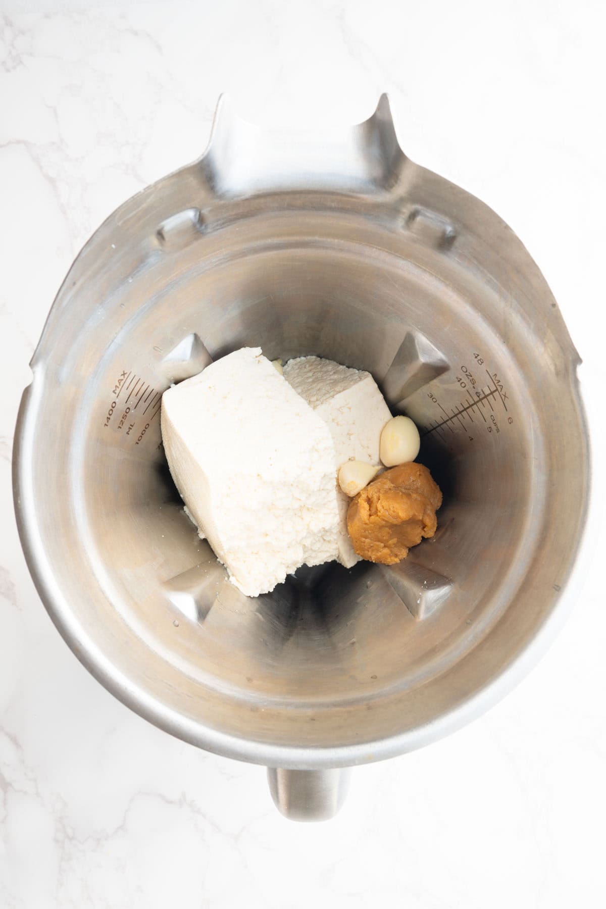 Tofu, miso, nutritional yeast, garlic, and lemon juice in a blender.