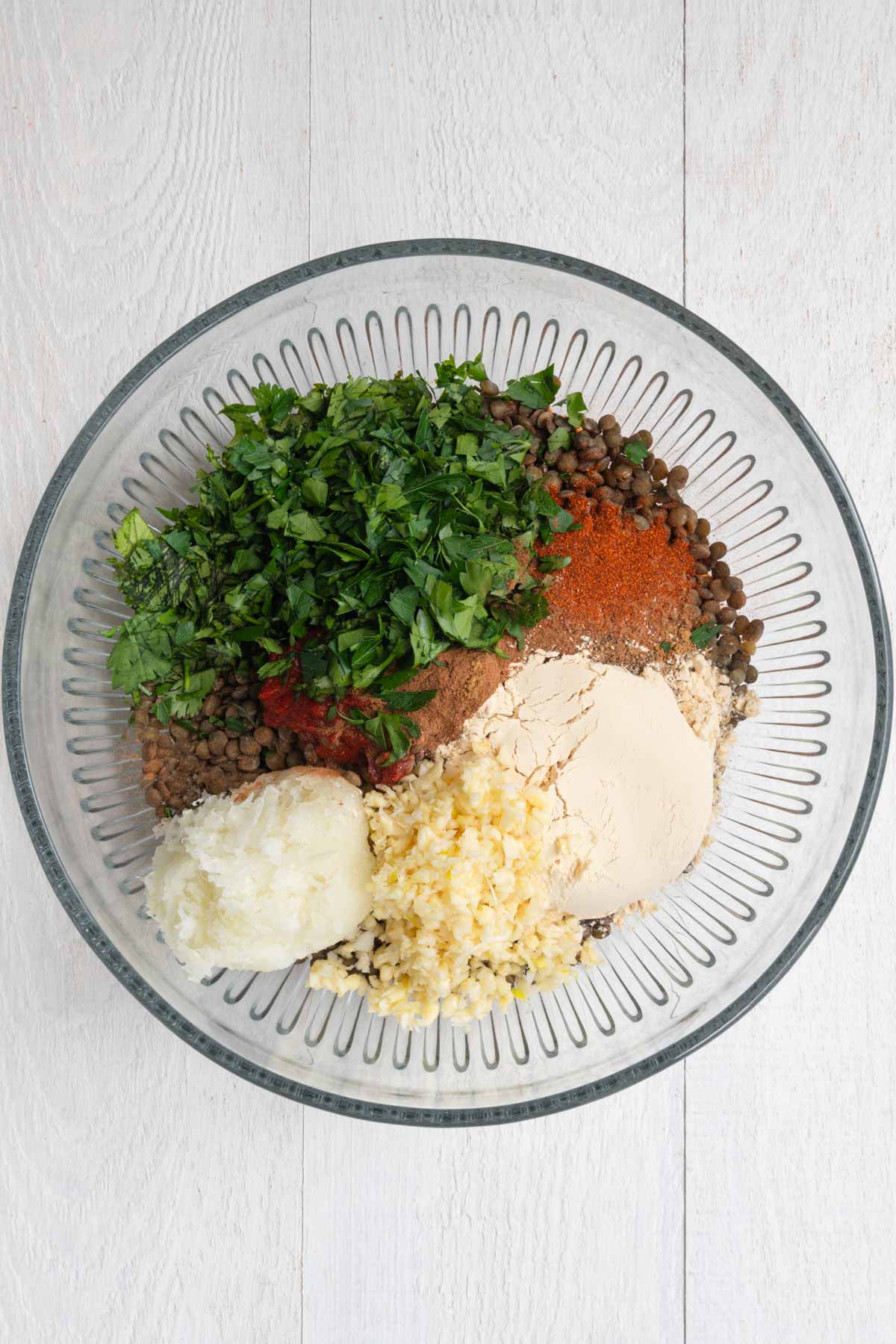 Lentils, grated onion, garlic, chopped parsley and cilantro, tomato paste, and seasoning.