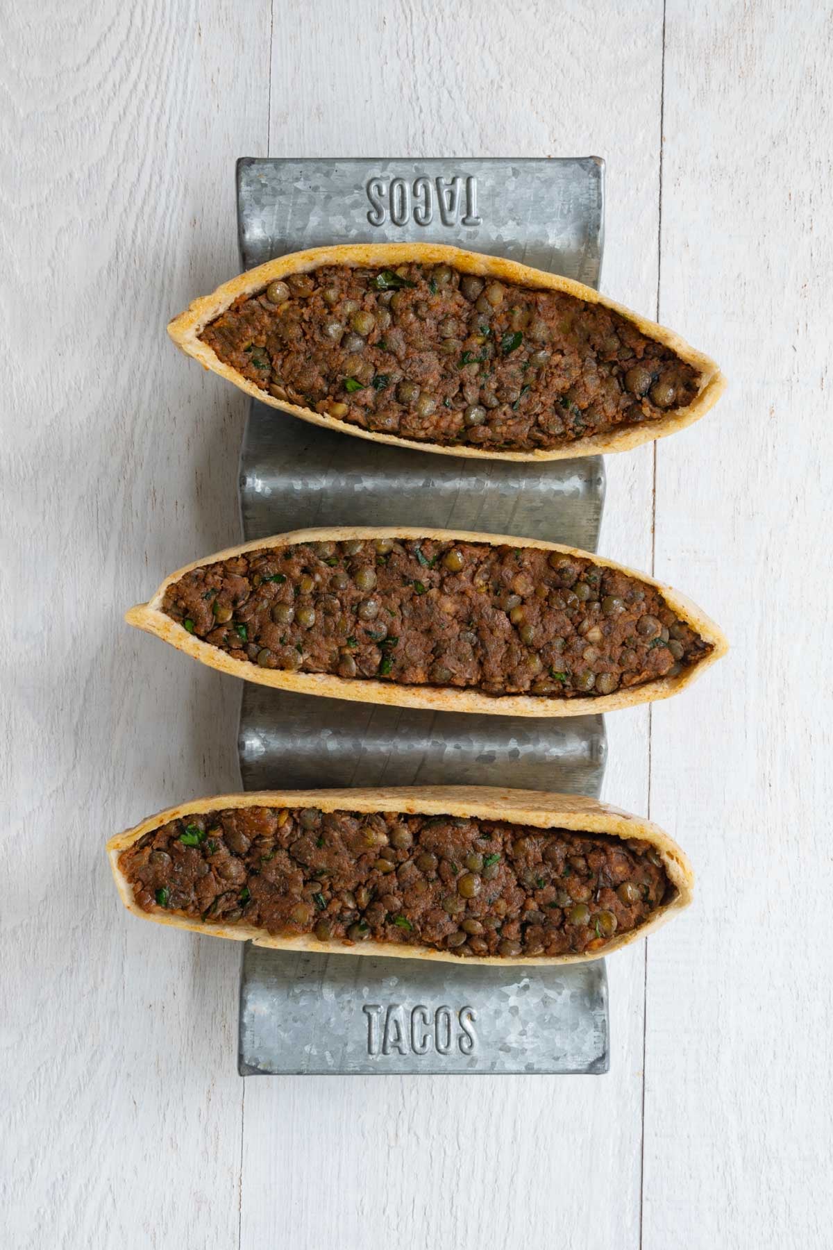 Three halved pita breads stuffed with a lentil filling.